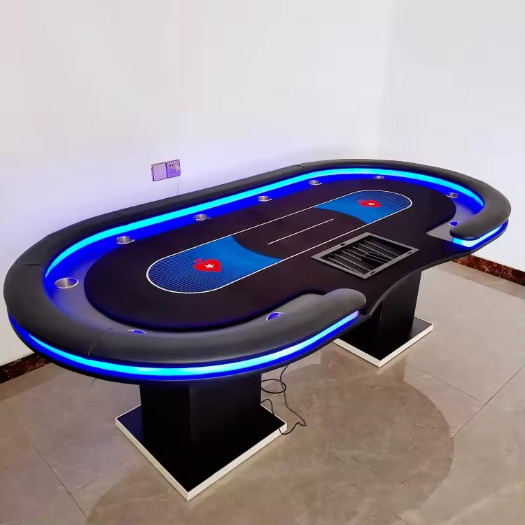 An oval - shaped poker table with blue LED lighting, black surface, and blue playing areas, placed in a room with a tiled floor and white walls.